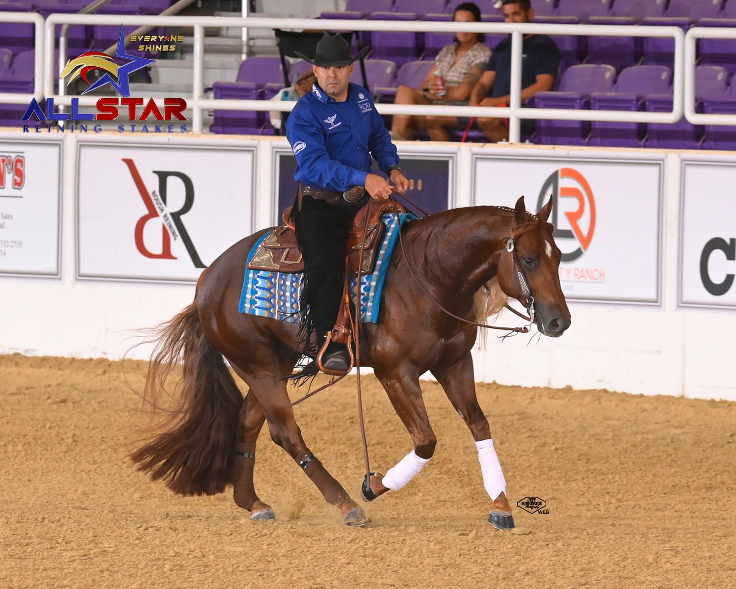 Robin Schoeller competing at the NRHA with a chestnut horse in a sliding stop